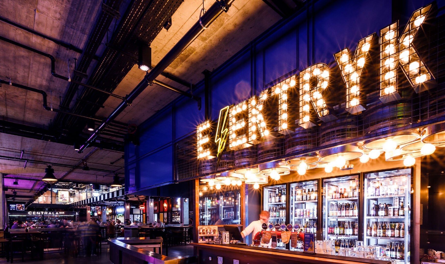 Lettere con lampadine sopra il bar e un'insegna al neon.